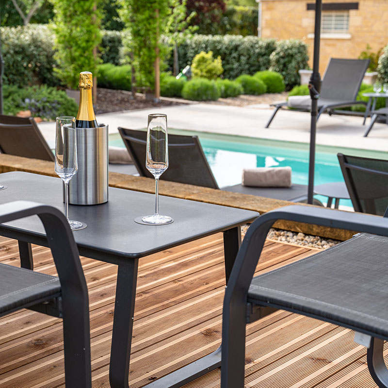 Enjoy a refreshing drink under the pergola by the pool Relaxing spot under the pergola by the pool with a refreshing drink